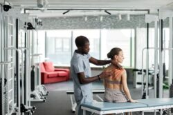 Physiotherapeut massiert Klientin an der Schulter