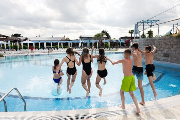 Gruppe von Jugendlichen springen in ein Außenpool