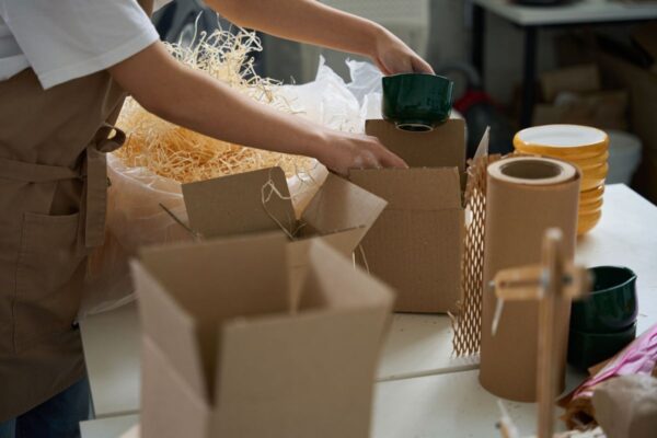 Verkäuferin verpackt Keramik als Erzeuger nach der EU-Verpackungsverordnung (PPWR)